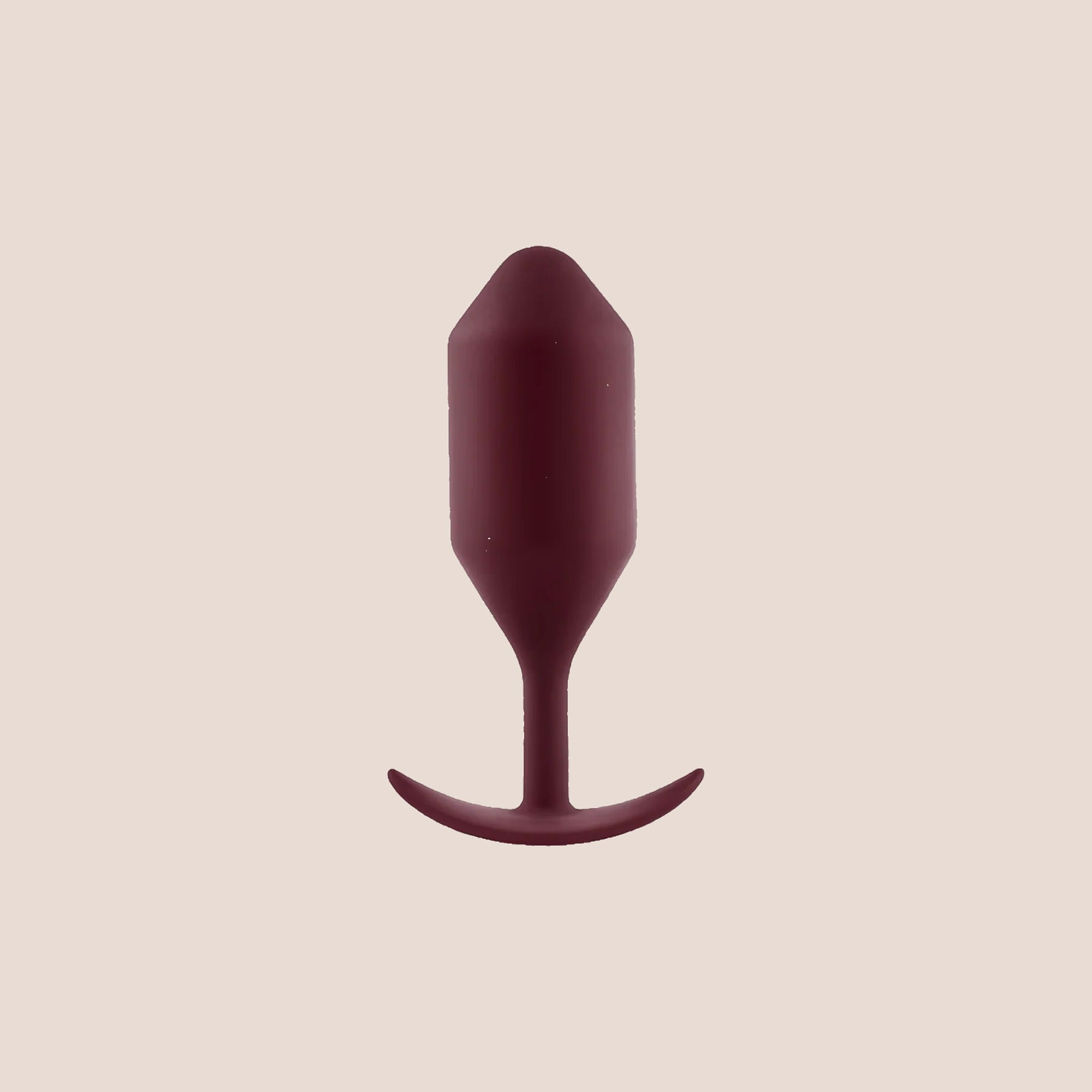 Borne — weighted intimate plug on a warm blush background