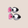 Illuminated — weighted intimate plug on a warm blush background