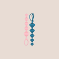 Seated — weighted intimate plug on a warm blush background